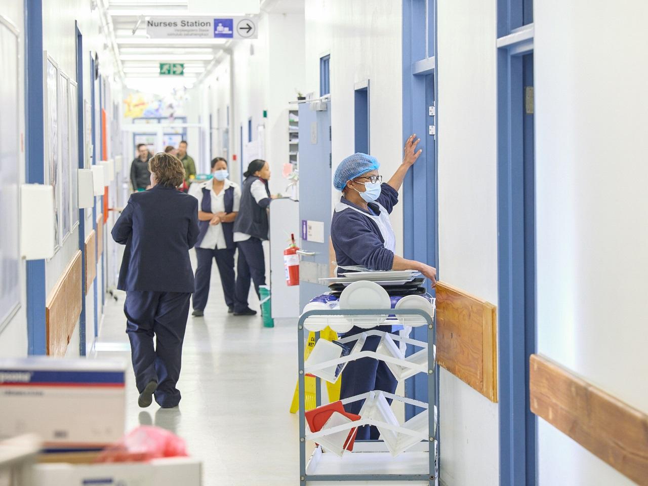 Busy atmosphrere in the hospital, with people walking the corridors.