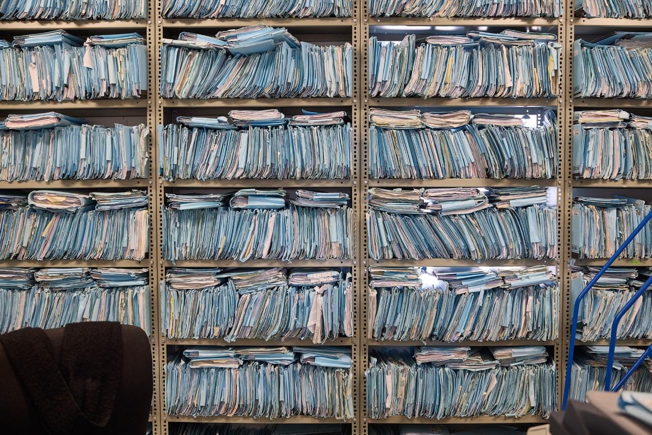 Mountains of patient files in a shelf.
