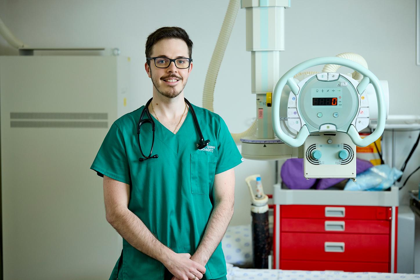 Jonathan Spanos, medical officer from George, SA, standing in front of an imaging machine. 