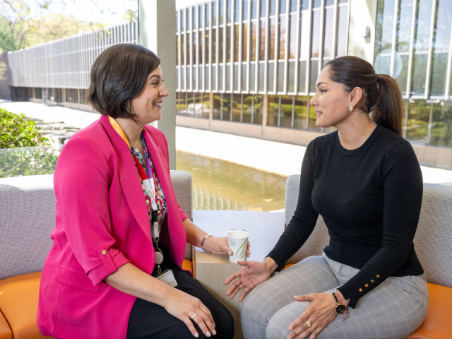 Two colleagues talking during a coffee break on a couch