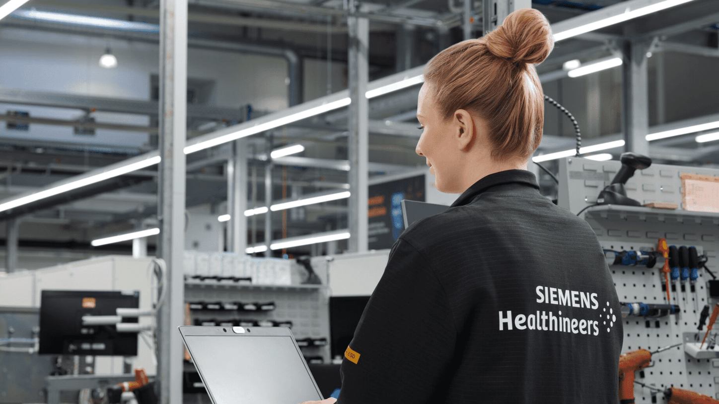 Werkstudentin arbeitet an ihrem Laptop in der Produktionsumgebung.